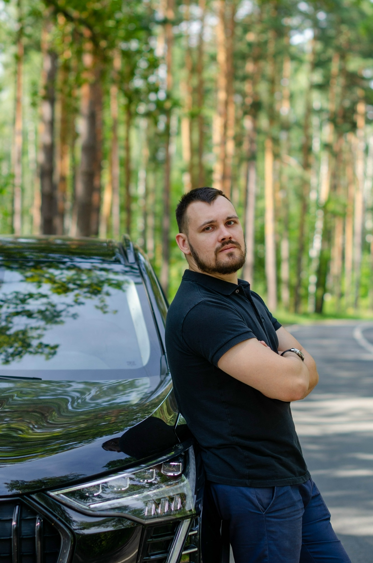 Владислав Зюзин у автомобиля на фоне соснового леса